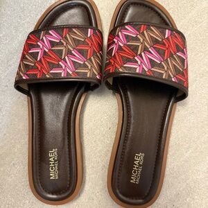 Michael Kors slide sandals in dark brown with pink emblems
